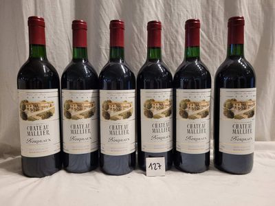 six bottles of red wine are lined up on a table