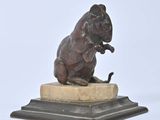 statue of a rat sitting on a marble base on a white background