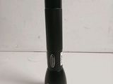 an image of a black flashlight on a white surface