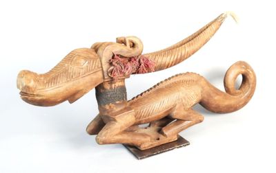 a wooden sculpture of an elephant with a red scarf