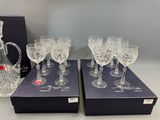 four wine glasses and a decanter are sitting on a table