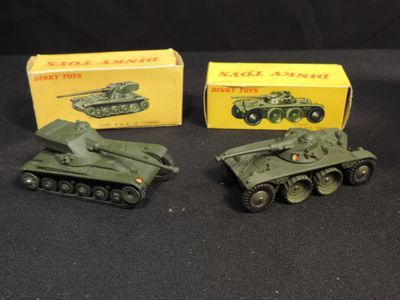 three toy army tanks are sitting next to each other on a black surface