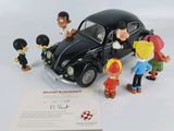 une petite voiture noire entourée d'un tas de figurines