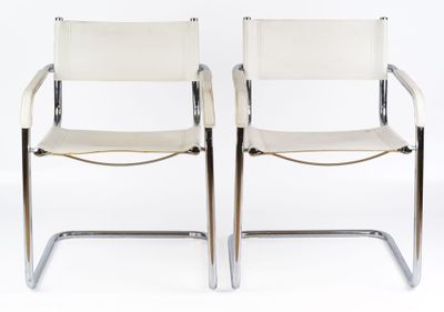 pair of chrome and leather chairs with white leather upholstered seats