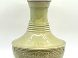 un vase vert posé sur une table