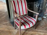 une chaise rayée rouge et blanche placée devant une cheminée