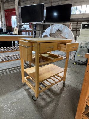 une table en bois surmontée d'une étagère, au milieu d'une pièce