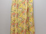 a yellow floral skirt hanging on a white wall
