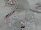 a glass swan shaped bowl sitting on a table next to a plate of cookies