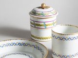 two cups and a saucer sitting on a table