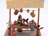figurines of people sitting at a table with a sign above them