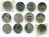 Plusieurs pièces de monnaie différentes sont présentées sur une surface blanche, accompagnées d'un petit bout de papier