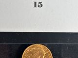 a close up of a gold coin on a black surface