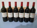 six bouteilles de vin rouge sont alignées sur une table