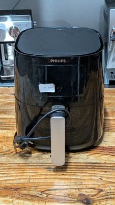 a black air fryer sitting on a wooden table