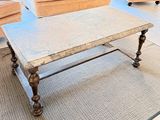 une table basse avec un plateau en marbre dans un salon