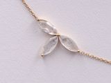 a close up of a gold chain necklace with clear quartz beads