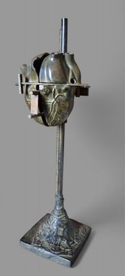a metal sculpture of a human heart on a stand