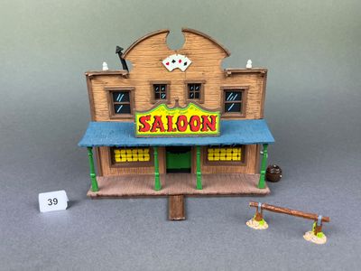 un petit bâtiment en bois avec une enseigne indiquant « saloon »