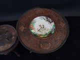 a plate with a picture of a cat on it next to a coin