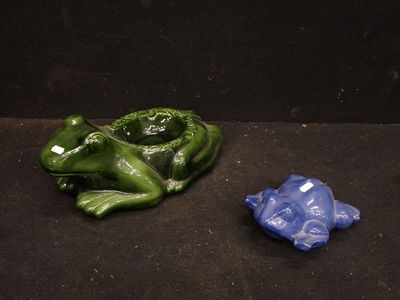 deux figurines représentant une grenouille et une autre grenouille, posées sur un fond noir