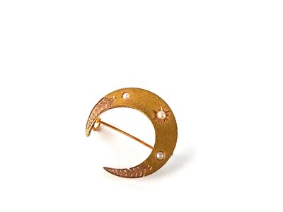 broche en forme de croissant doré, ornée d'étoiles et de croissants