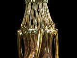 a gold vase that is sitting on a black surface