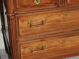 a wooden dresser with marble top in a room