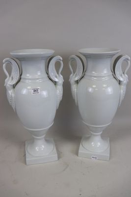 two white vases with handles on each of them