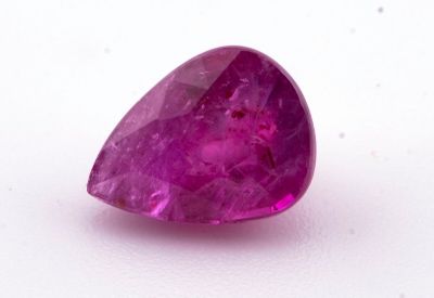 un gros plan d'un saphir rose posé sur une surface blanche