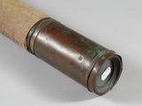 an old telescope with a wooden handle on a white surface