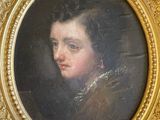 portrait of a young man in a gold frame in a room