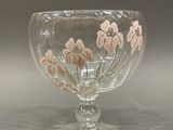 a glass bowl with flowers painted on it on a table
