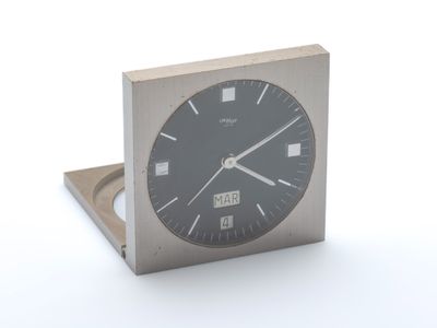 une horloge en métal avec un cadran noir sur un fond blanc