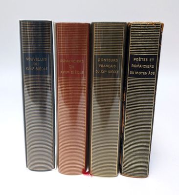 trois livres superposés sur une surface blanche