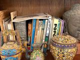 books and vases on a wooden shelf in a room