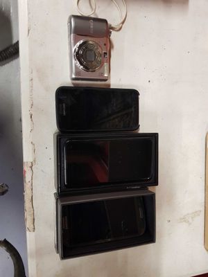 several cell phones are stacked on top of each other on a shelf