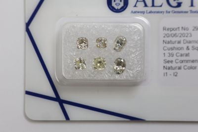 cinq diamants de couleurs différentes présentés dans un emballage posé sur une carte