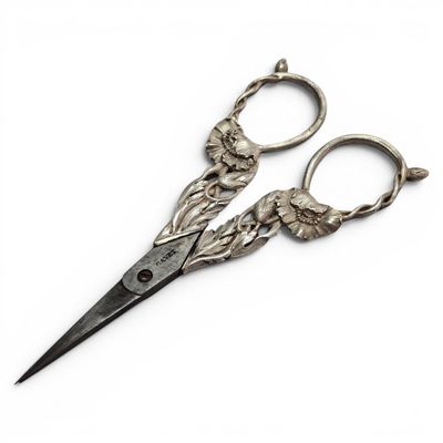 pair of antique scissors on a white surface with a white background