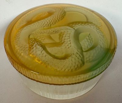 a yellow bowl with a snake on it on a white surface