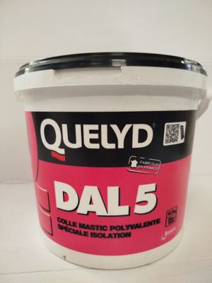 un gros plan sur un seau de peinture « Dal 5 » posé sur une table