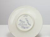 two plates with writing on them sitting on a table