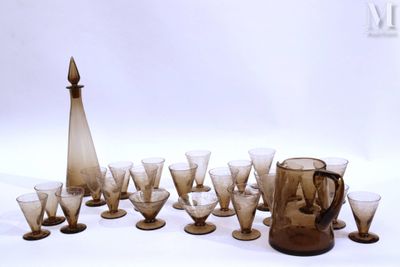 des bouteilles et des verres sont disposés en cercle sur une surface blanche