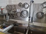 many pots and pans hanging on the wall in the kitchen
