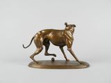 bronze sculpture of a dog running on a base with a ball