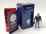 a figurine of a man in a suit and tie next to a box