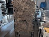 Plusieurs rouleaux de papier toilette sont empilés sur un chariot dans une cuisine