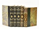 three books are stacked on top of each other on a white surface