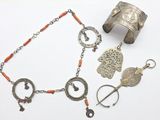 un bracelet en argent, un bracelet et d'autres bijoux posés sur une surface blanche