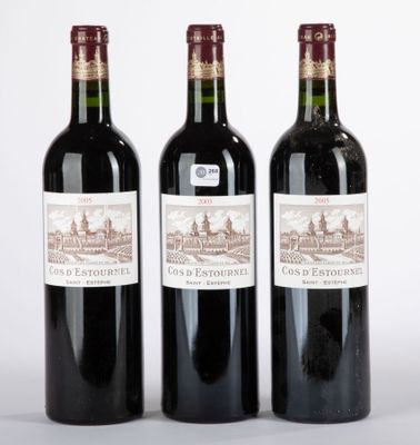 trois bouteilles de vin posées les unes à côté des autres sur une surface blanche
